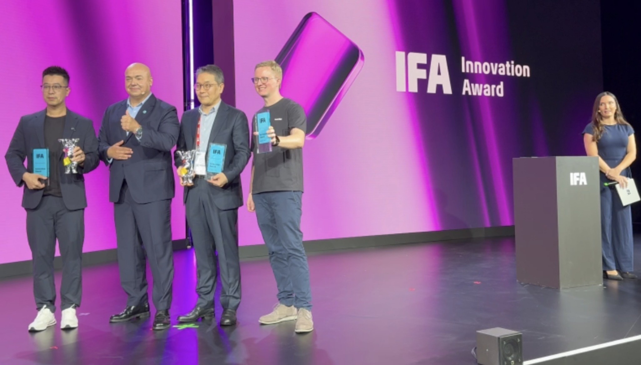 LG Electronics Schriftzug groß auf der Bühnenleinwand der Innovation Stage, davor zwei Personen bei der Übergabe der Best Brand Trophäe